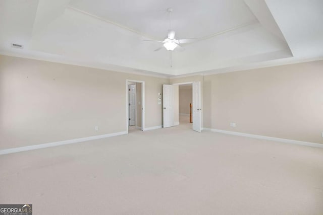 unfurnished room featuring crown molding, light carpet, ceiling fan, and a tray ceiling