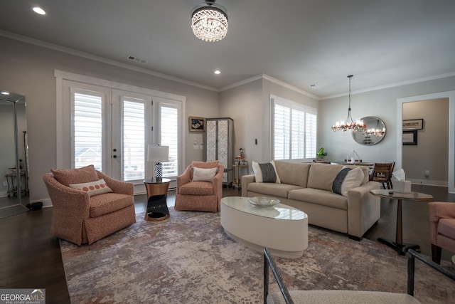 living room with crown molding, dark wood-type flooring, and a chandelier