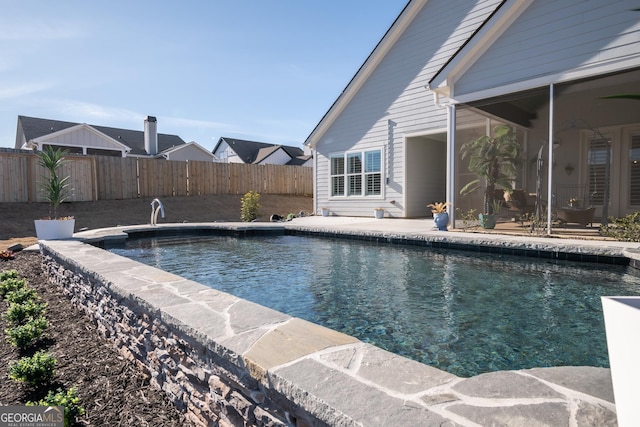 view of swimming pool featuring a sunroom and a patio