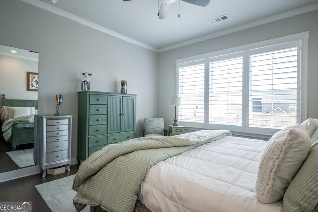 bedroom with ornamental molding, dark wood-type flooring, and ceiling fan