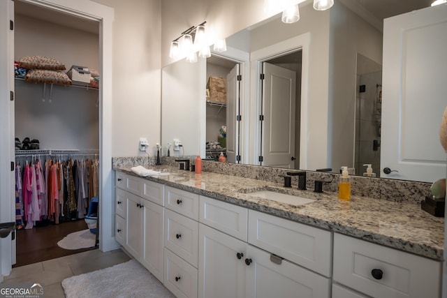 bathroom featuring tile patterned flooring, vanity, and an enclosed shower