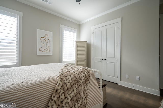 bedroom with ornamental molding, dark hardwood / wood-style flooring, and a closet