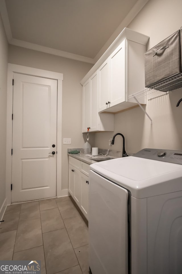 laundry room featuring sink, crown molding, light tile patterned floors, cabinets, and washing machine and clothes dryer