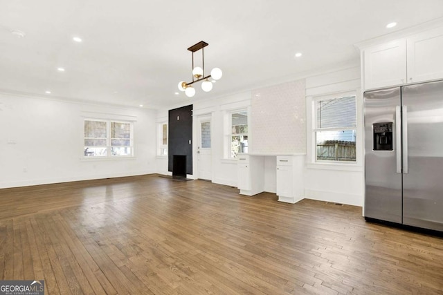 kitchen featuring white cabinets, dark hardwood / wood-style floors, stainless steel fridge, and a chandelier