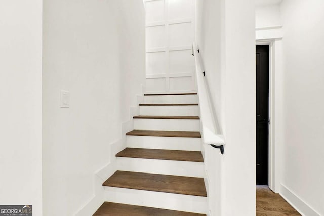 staircase with hardwood / wood-style floors