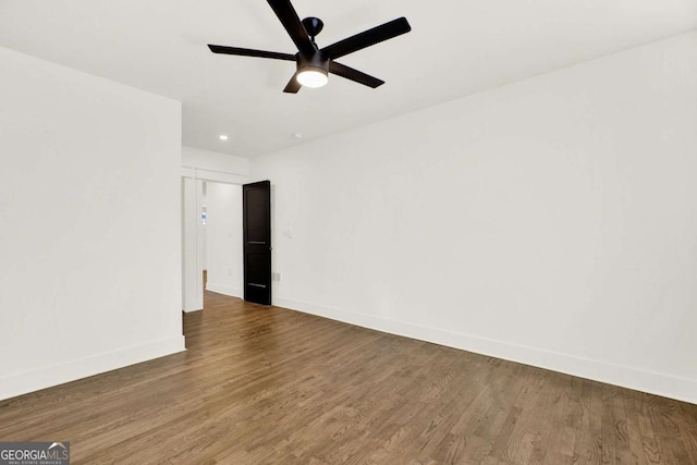 empty room with dark hardwood / wood-style flooring and ceiling fan