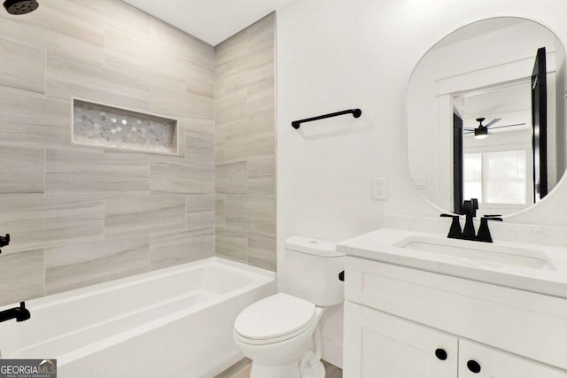 full bathroom featuring vanity, tiled shower / bath, and toilet