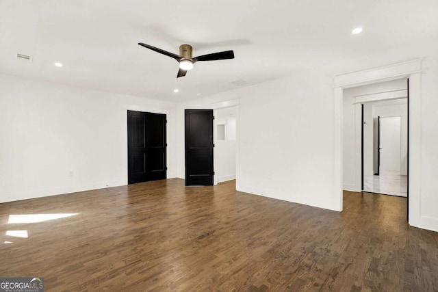 spare room with dark hardwood / wood-style flooring and ceiling fan