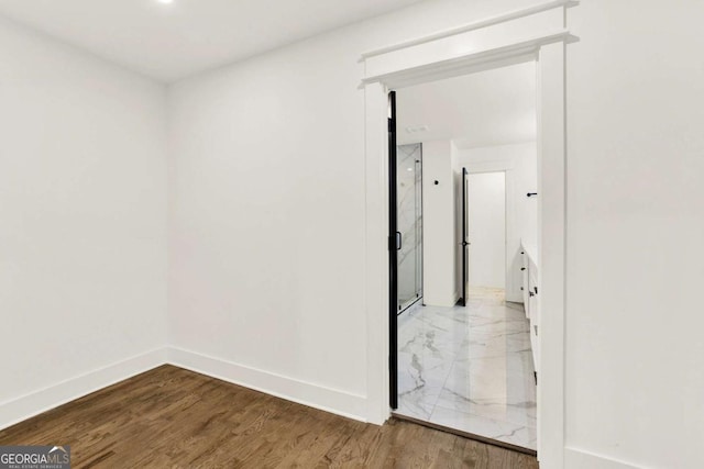 corridor with hardwood / wood-style floors