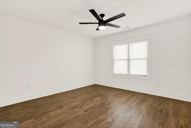 spare room with ceiling fan and dark hardwood / wood-style flooring