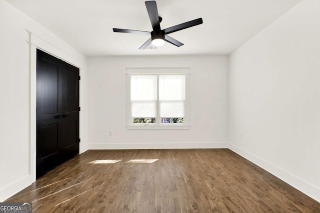 unfurnished room with dark wood-type flooring and ceiling fan