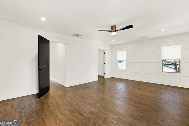 spare room with dark wood-type flooring and ceiling fan