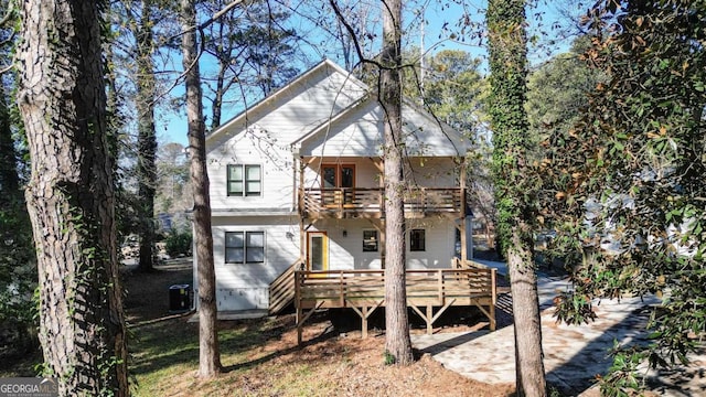 rear view of property featuring a balcony and central air condition unit