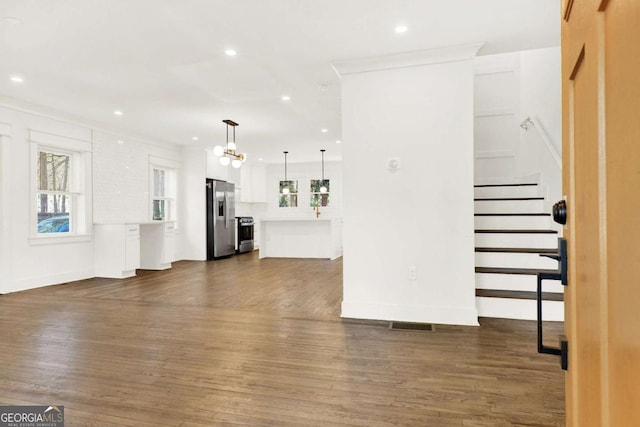 unfurnished living room with dark wood-type flooring and a notable chandelier