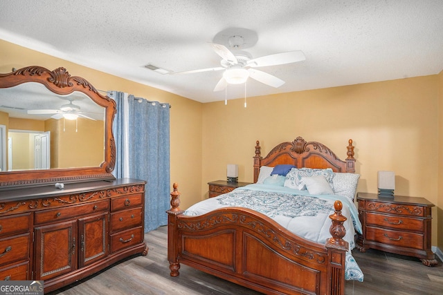 bedroom with ceiling fan, wood-type flooring, and a textured ceiling