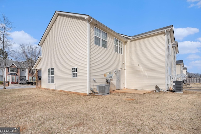 view of side of property with central AC and a lawn