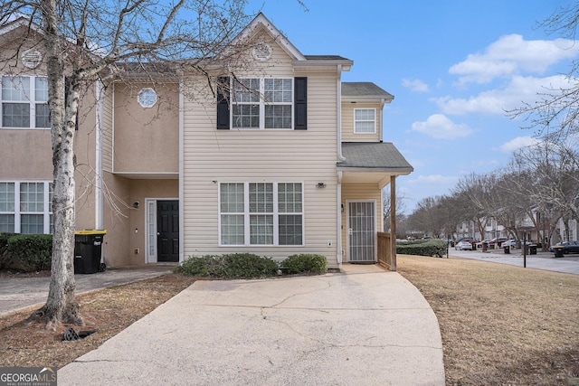 townhome / multi-family property with a front yard