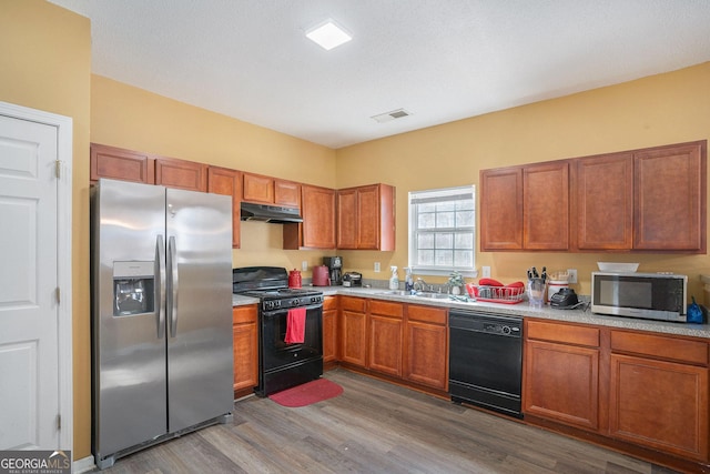 kitchen featuring hardwood / wood-style flooring, sink, and black appliances