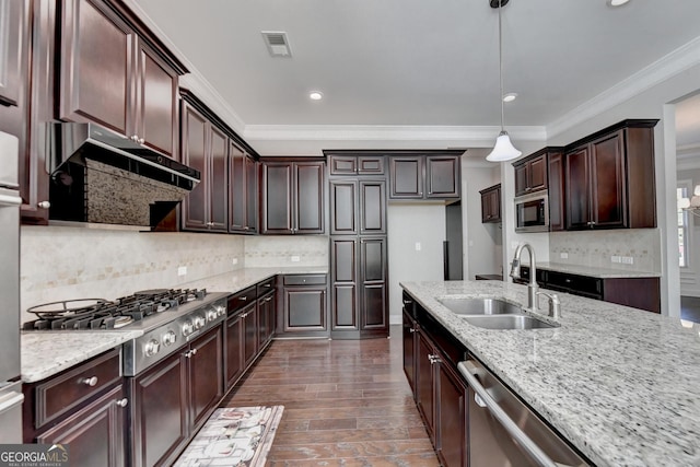kitchen featuring pendant lighting, sink, stainless steel appliances, dark brown cabinetry, and light stone countertops