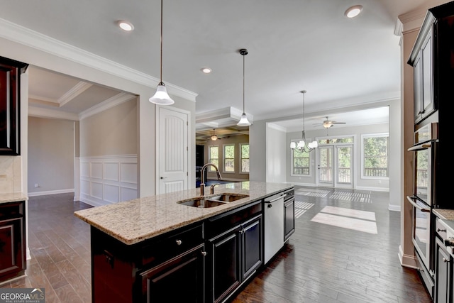 kitchen with pendant lighting, sink, dark hardwood / wood-style flooring, stainless steel appliances, and a center island with sink