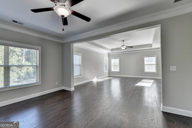 empty room with crown molding, ceiling fan, a tray ceiling, and dark hardwood / wood-style flooring