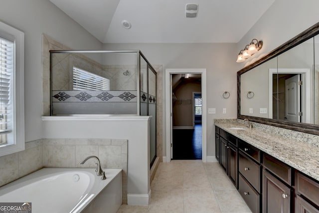 bathroom with shower with separate bathtub, vaulted ceiling, vanity, and tile patterned floors