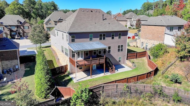 back of house featuring a wooden deck and a patio area