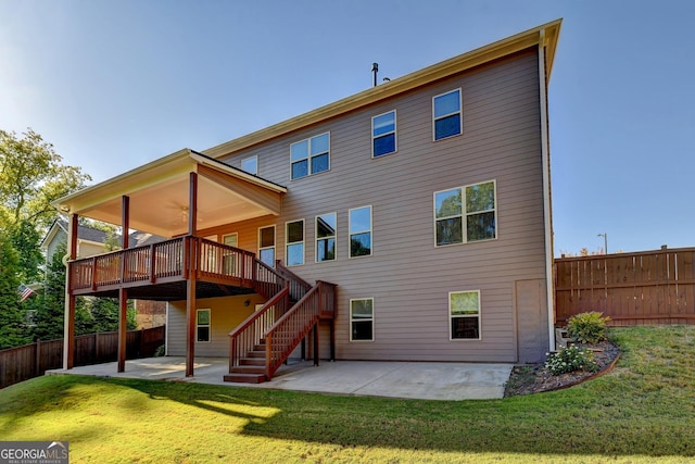 rear view of property with a yard, a deck, and a patio area