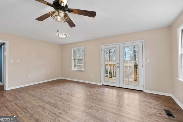 empty room with hardwood / wood-style floors, ceiling fan, and french doors