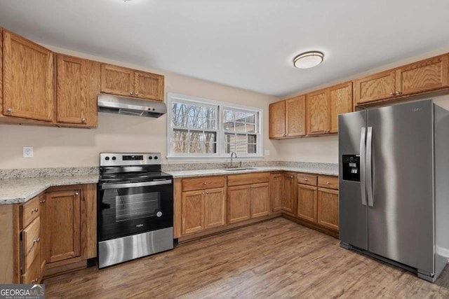 kitchen with stainless steel appliances, light hardwood / wood-style floors, and sink