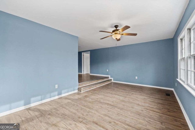 empty room with hardwood / wood-style flooring and ceiling fan