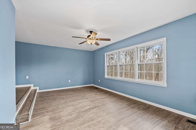 spare room with hardwood / wood-style floors and ceiling fan