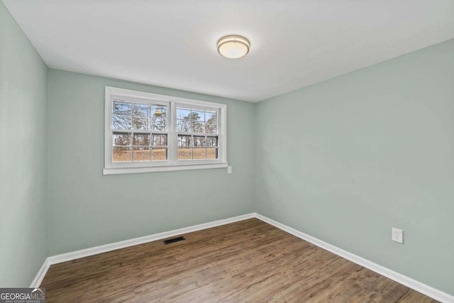 spare room featuring wood-type flooring