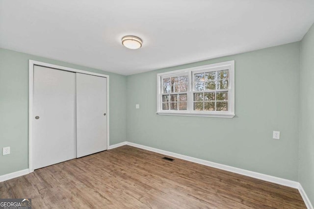 unfurnished bedroom featuring hardwood / wood-style floors and a closet