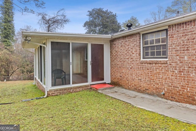 entrance to property with a lawn
