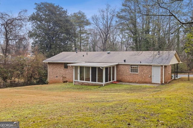 rear view of property featuring a yard and a sunroom