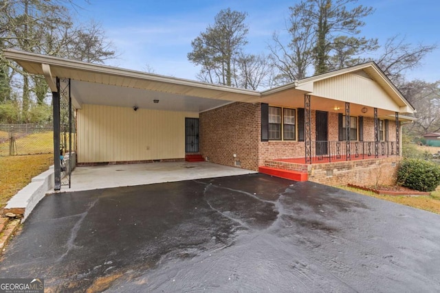 ranch-style home with a carport and covered porch