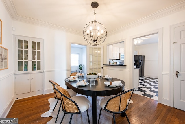 dining room with ornamental molding, dark wood-type flooring, and an inviting chandelier