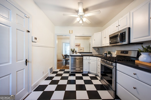 kitchen with tasteful backsplash, white cabinetry, sink, ceiling fan, and stainless steel appliances