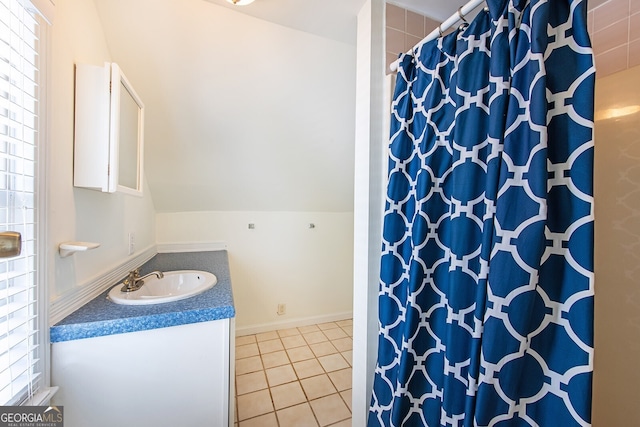 bathroom with tile patterned flooring, vanity, and lofted ceiling