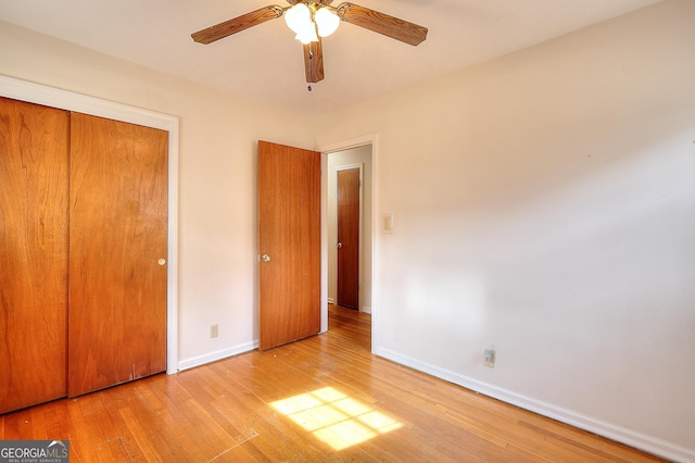 unfurnished bedroom with ceiling fan, a closet, and light wood-type flooring