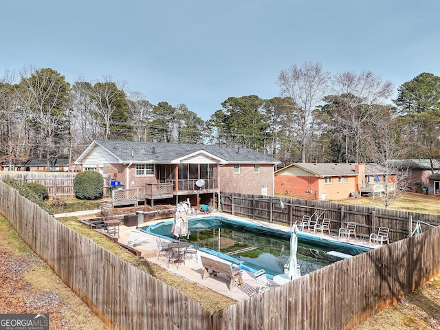 view of pool featuring a sunroom, a deck, and a patio area