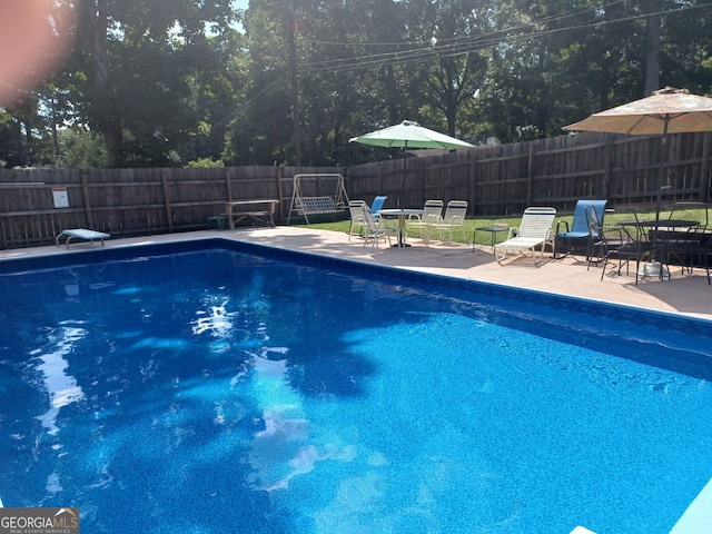 view of swimming pool with a diving board and a patio area