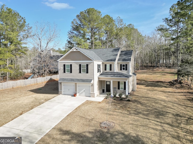 view of front of home featuring a porch, a garage, and a front yard