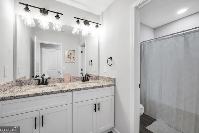 bathroom with vanity, hardwood / wood-style floors, and toilet