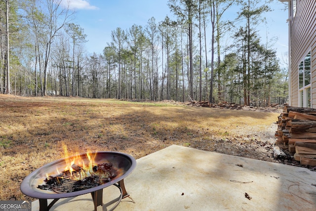 view of yard featuring a patio and an outdoor fire pit