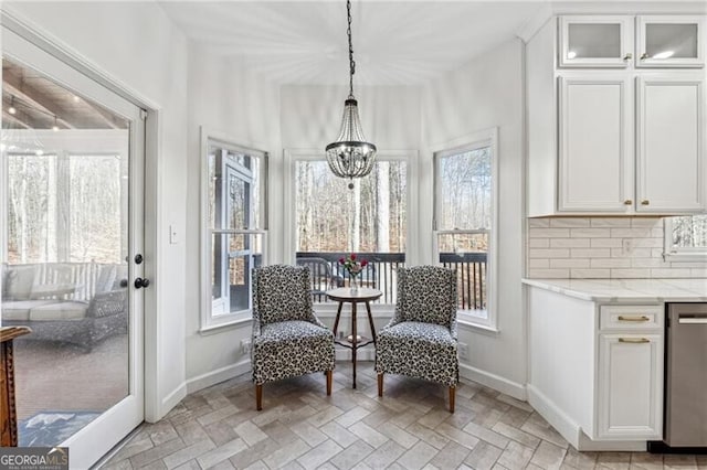 sunroom / solarium featuring an inviting chandelier