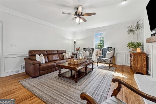 living room featuring crown molding, hardwood / wood-style floors, and ceiling fan