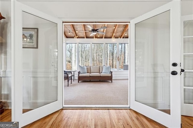 doorway featuring ceiling fan, wood-type flooring, wooden ceiling, french doors, and beamed ceiling