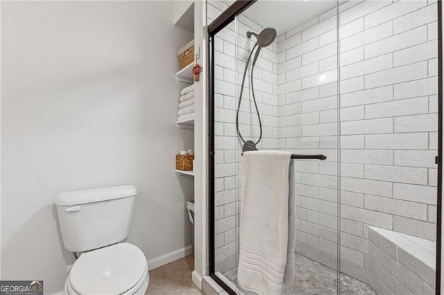 bathroom with a shower with shower door and toilet